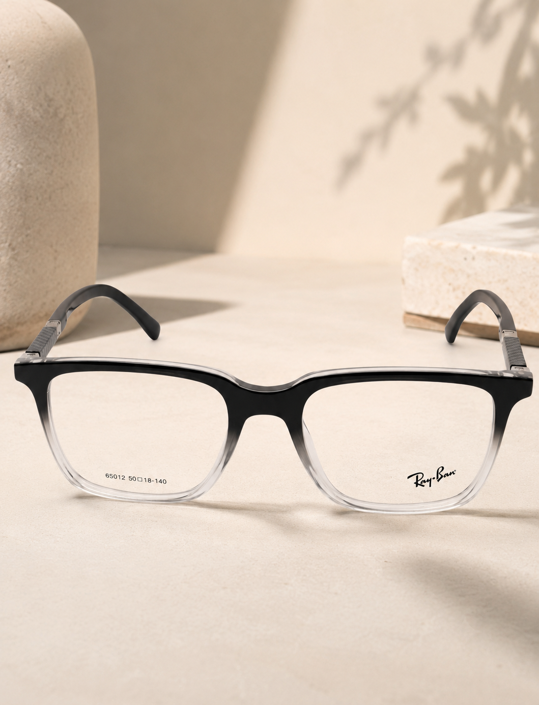 Ray-Ban 65012 Black Clear Gradient - Lifestyle Neutral Surface with Plant Shadow
